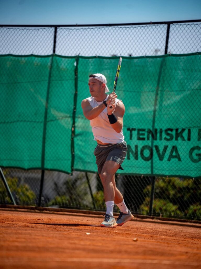 Bruno igra tenis na zemljanom terenu