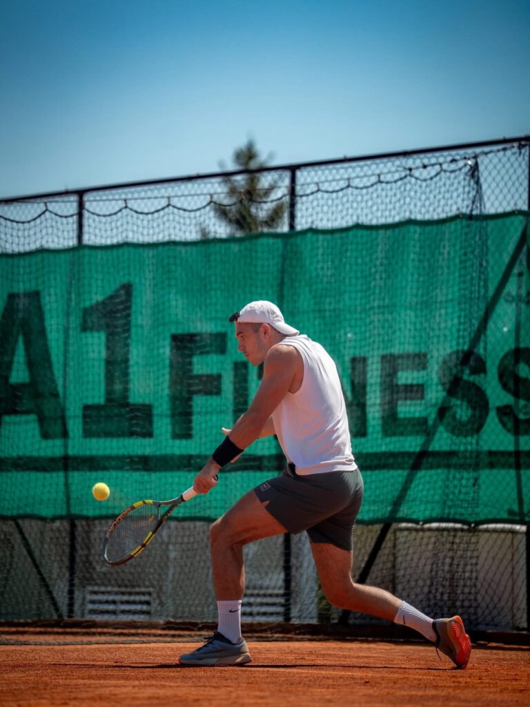 Bruno igra tenis na zemljanom terenu