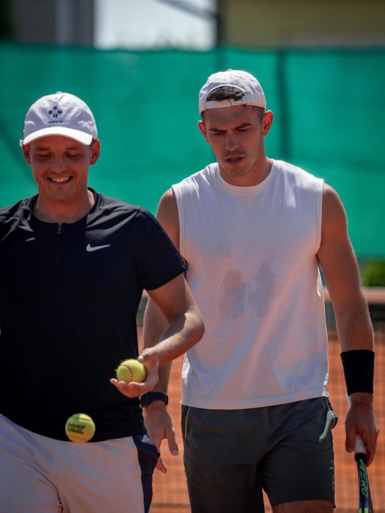 Bruno igra tenis na zemljanom terenu